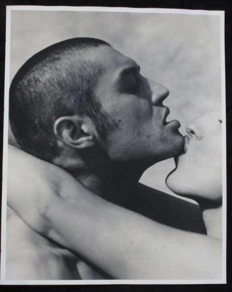 Michel Comte (1954-) Print of Couple: Black and white photographic print on baryta paper by acclaimed fashion photographer Michel Comte. Depicting a woman kissing a man's chin. Artist's marks in pencil to verso. 20 inches height and 16 in