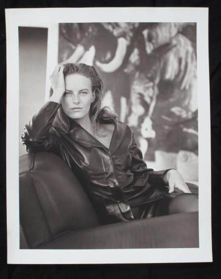 Michel Comte (1954-) Photographic Print: Black and white photographic print on baryta paper by Michel Comte. Depicting a female model in a leather jacket seated with her head resting on her hand. Artist's marks in pencil and stamp to verso.