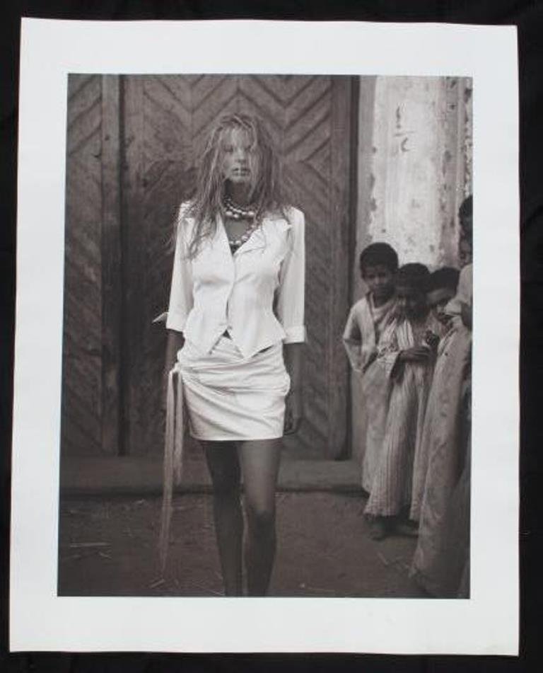 Michel Comte (1954-) Black and White Print: Black and white photographic print on baryta paper by fashion photographer Michel Comte. Depicting a female model with hair covering her face and a group of young children to the right. Artist's marks