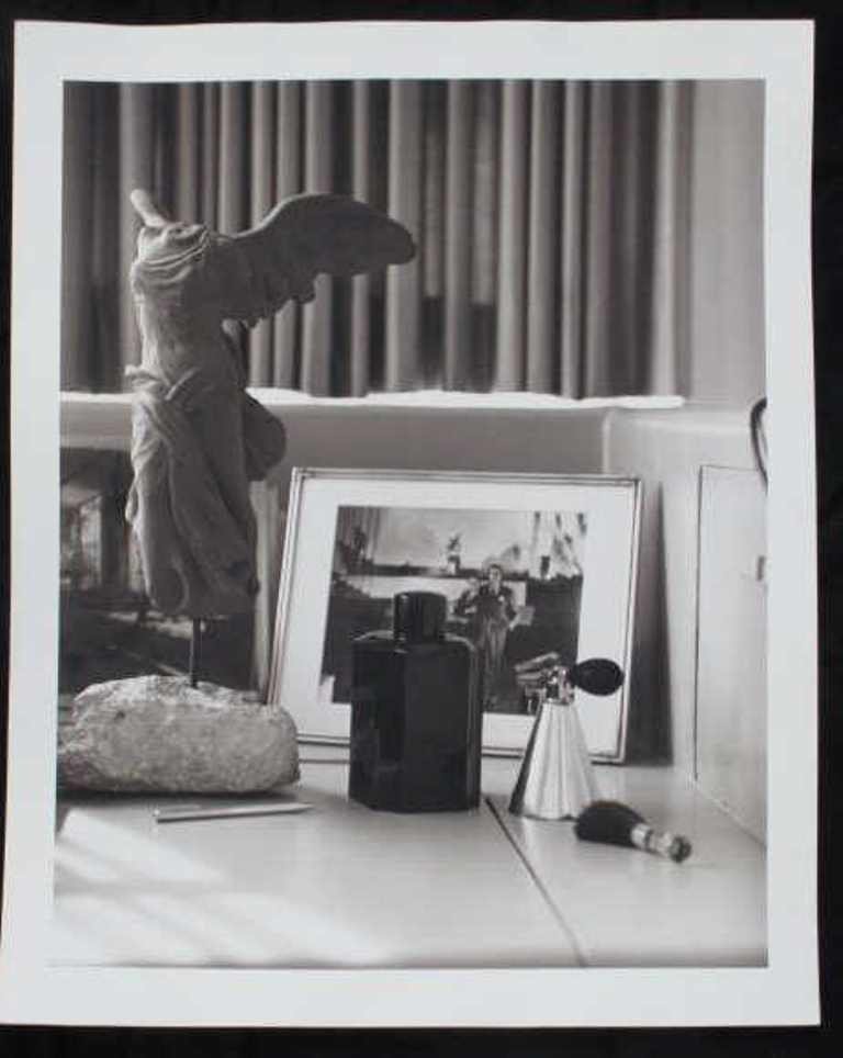 Michel Comte (1954-) Still Life Print: Black and white photographic print on baryta paper by Michel Comte. Depicting a still life scene with perfume bottles and a small model of the Nike of Samothrace on a surface. Artist's marks in pencil