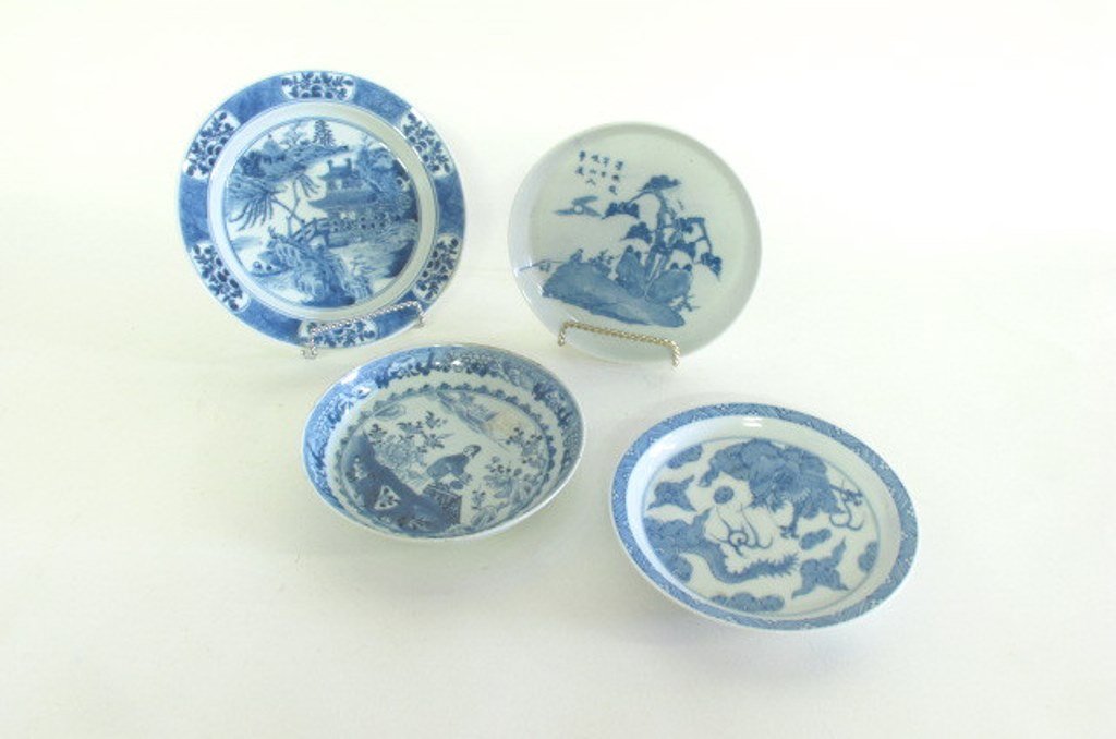 Grouping of Four Chinese Blue and White Dishes: Four Chinese blue and white plates with different maker's marks to each. One having landscape scene with pagoda and foliage, one having floral motif with female figure, one rocky landscape with trees 