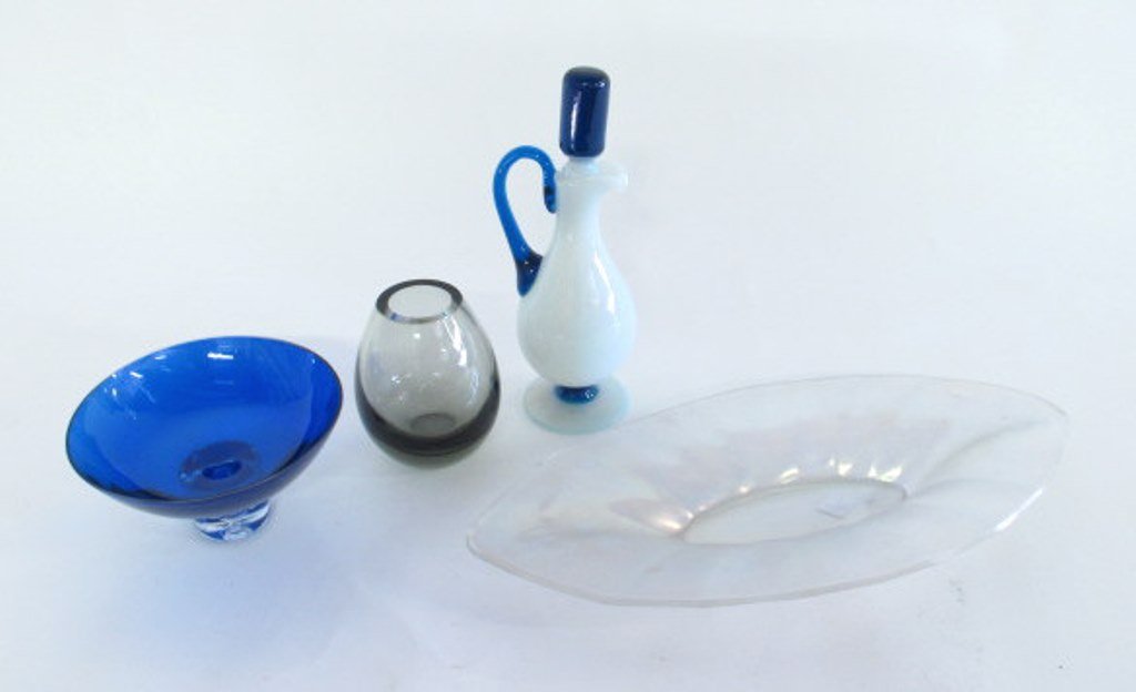 Quartet of Glass and Crystal Pieces: Three decorative glass pieces and one crystal vase. Small clear crystal vase with gray tint marked "Holmegaard 1961" to bottom, white glass cruet with blue stopper and blue rigaree handle, iridescent