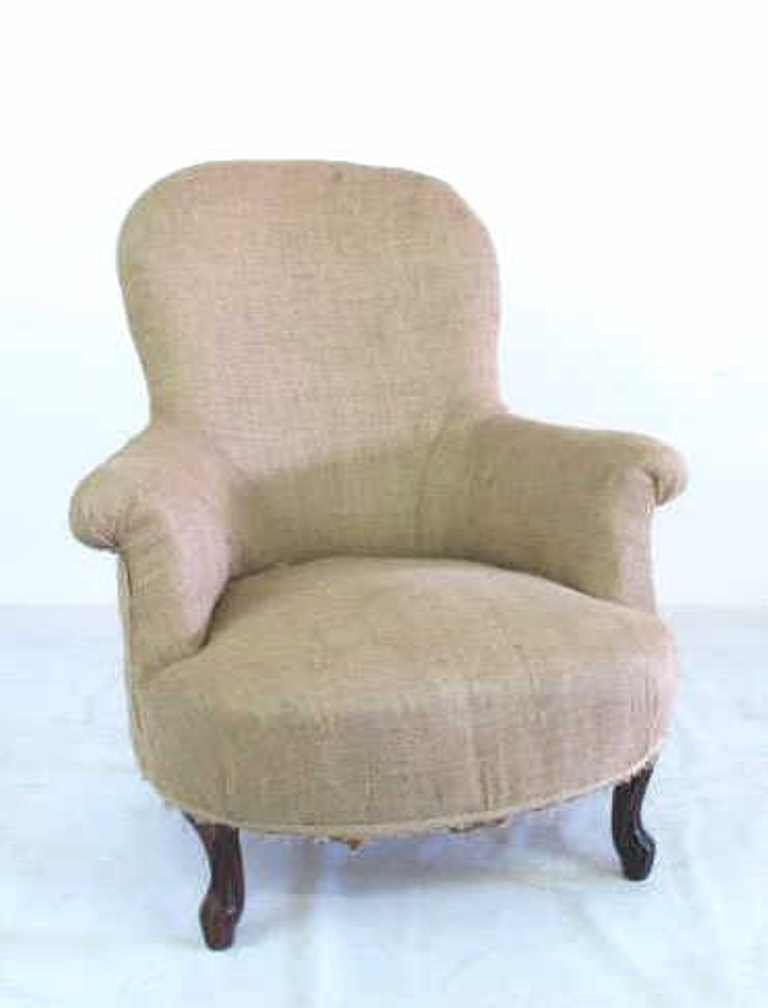 Upholstered Chair: Upholstered armchair with burlap like woven fabric in a tan color. Rounded back, wear to fabric on bottom. 43.5 inches height, 29 inches width, 24.5 inches depth. 43.5"H x 29"W x 24.5"D Wear to bottom