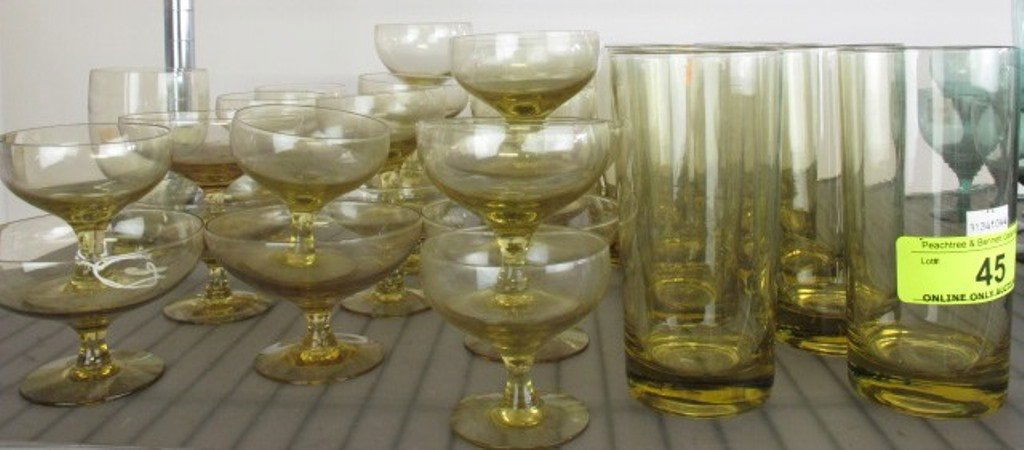Group Lot of Assorted Russel Wright Stemware: In amber colors. Consisting of drink and Champaign glasses in various forms. Approximately: 36 pieces. Dimensions: