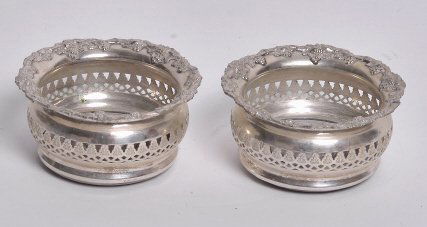 Pr Silverplated Wine Coasters: Each with a grape vine and leaf top rim and centered by a turned inlay mahogany bottom. 2 inches height, 4.50 inches diameter. Provenance: From a Private Collection of Prestigious Sarasota, Florida Re