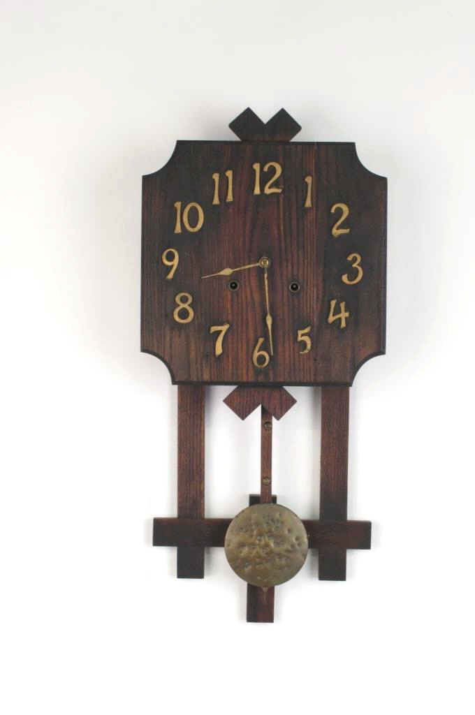 Wall Clock with Pendulum: Wooden wall clock having gold painted numerals and brass hands to face. Squared form with hanging bronze pendulum. 28.5 inches height, 13 inches width, 4.5 inches depth. 28.5"H x 13"W x 4.5"D DIMENSIO