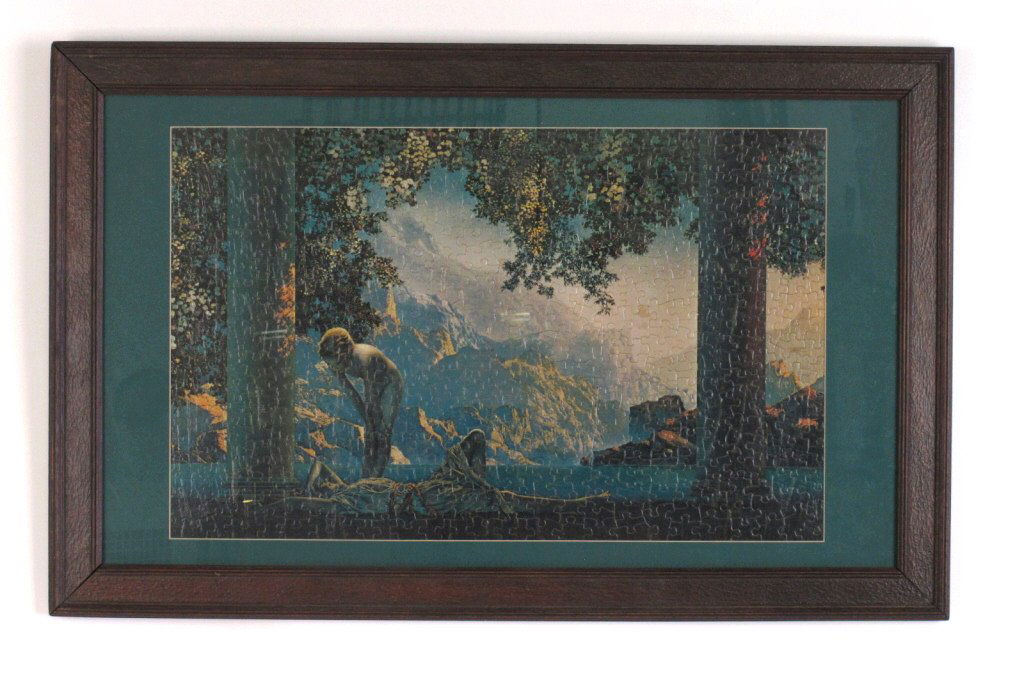 Jigsaw Puzzle of Maxfield Parrish's "Daybreak": Jigsaw puzzle printed with image of Maxfield Parrish's painting "Daybreak." Assembled and framed in wood. 15.5 inches height, 24.5 inches width. Frame measures 21.5 inches height, 34 inches width. 15.