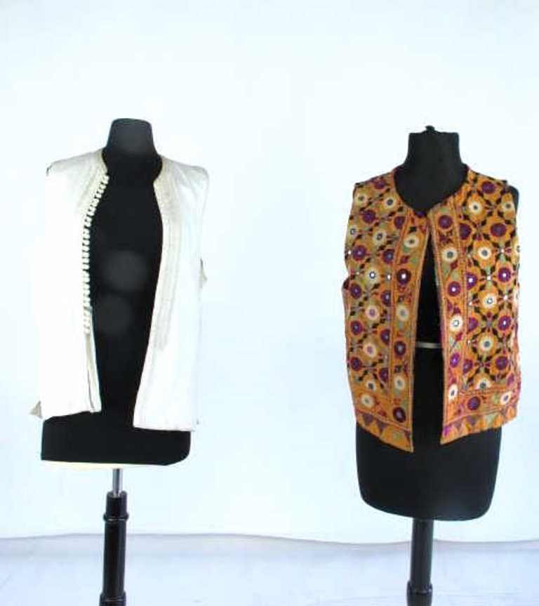 Two Embroidered Vests Two embroidered vests. One by: Two embroidered vests. One by Knobkerry having mirrored detail and colorful appearance. One white and embroidered with no label.