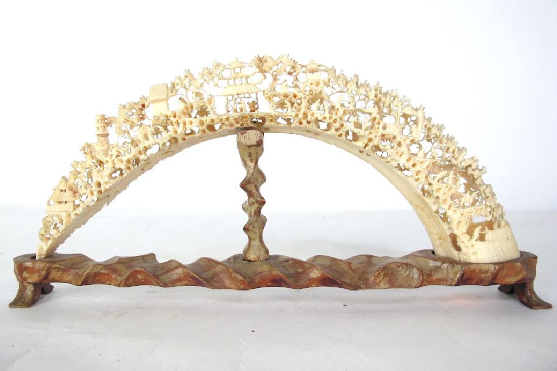 Chinese Carved Ivory Sculpture with Wood Base Carved: Carved ivory tusk sculpture having depictions of Chinese buildings and figures with animals among foliage. On a custom carved wood base. 6.5 inches height, 14.5 inches width, 2 inches depth. 6.5"H x 1