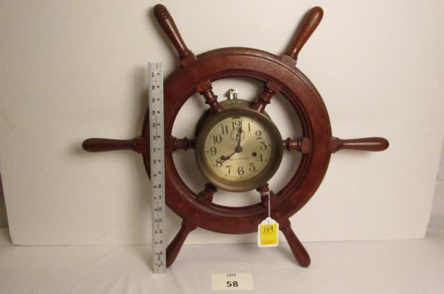 Ship's Clock: Seth Thomas brass ship's clock centered in a wood ship's wheel. Time and strike, working with key.