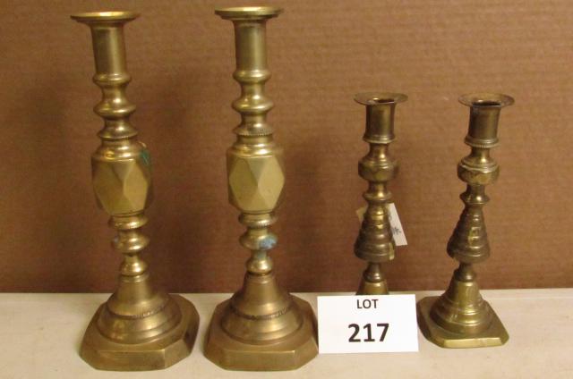 Two pairs of vintage brass candlesticks. One pair: Two pairs of vintage brass push up candlesticks. One pair measures 11.5" high, the other pair measures 8.75" high, marked England. One candlestick is loose, but stands erect. Both have age-related wea