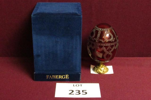 Faberge' egg: Faberge' signed, boxed red glass egg with etched decoration and gold decorative attached metal stand 4 1/2" tall x 2 1/2" wide