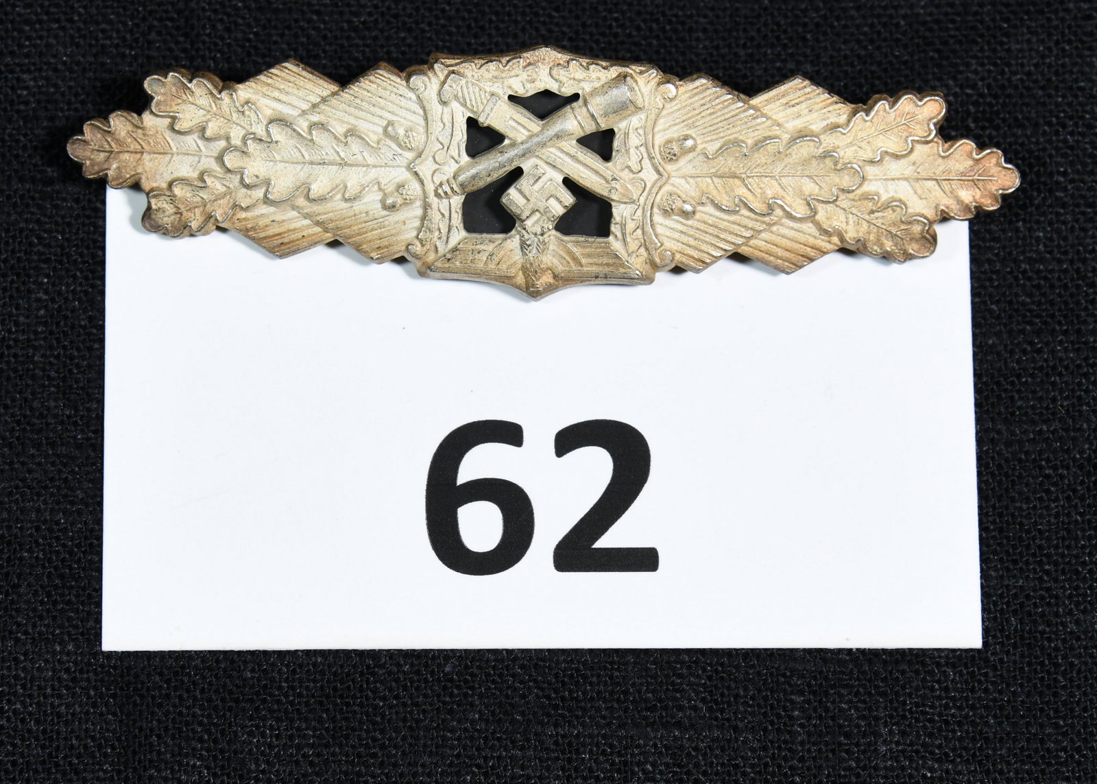 WWII German Close Combat Silver Class Clasp: A WWII German close combat silver class clasp given for participation in hand to hand combat. The clasp has an eagle and swastika symbol at the center with two crossed bayonets. Each side has a spray 