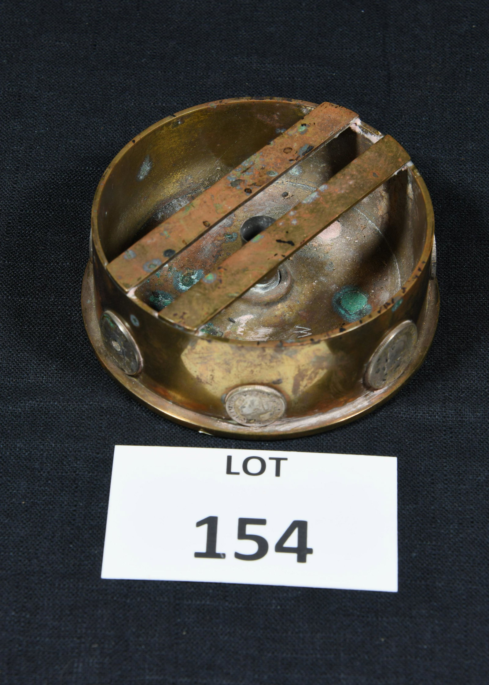 WWII Era European M14 Shell Art Ashtray: A WWII era M14 artillery shell art ashtray. Several European coins are affixed to the side of the cylinder. Two bars attached to the top for holding cigarette or cigar of your choice. Dated 1943 on th