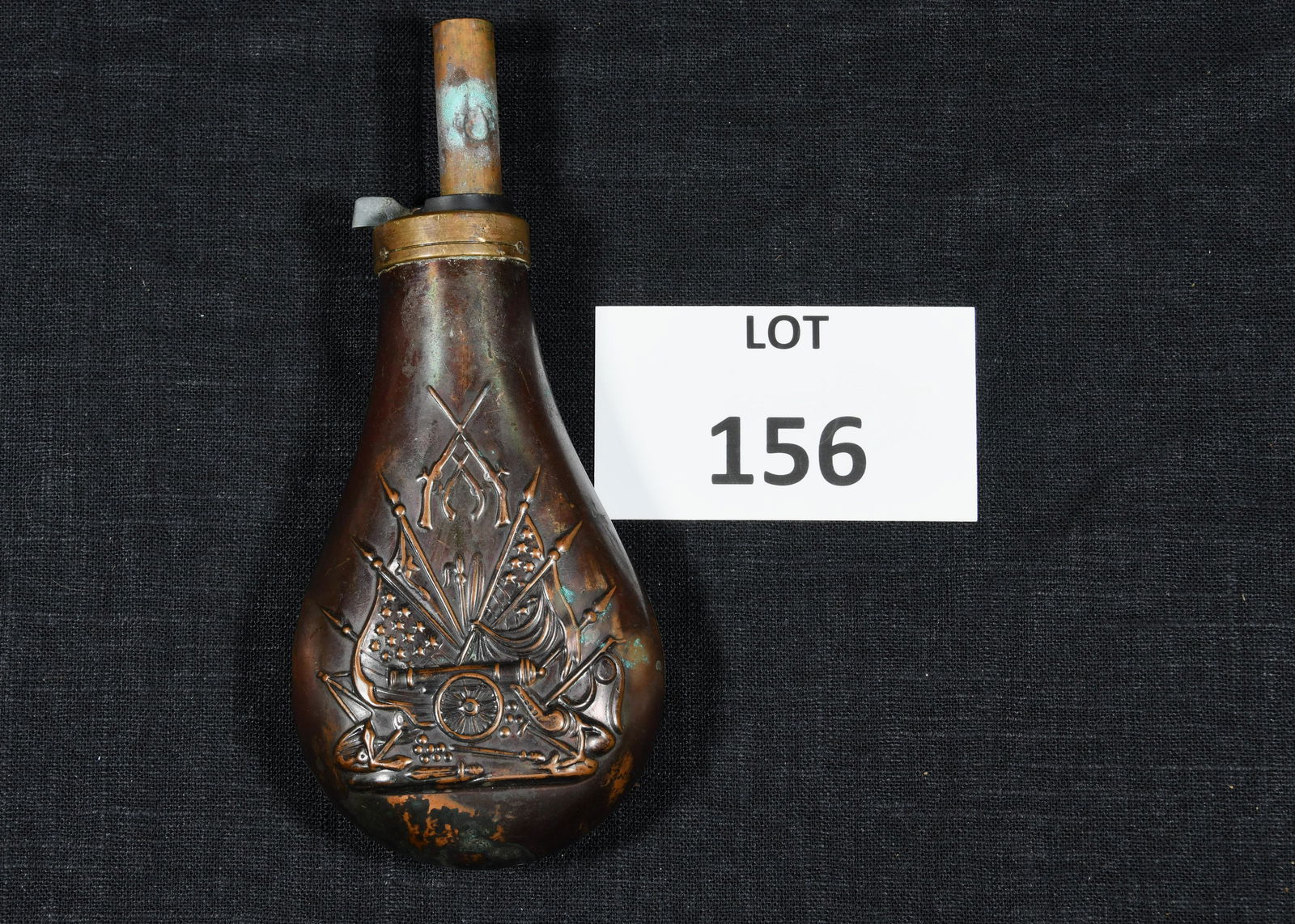 Civil War Era Brass Black Powder Flask: A Civil War era Union Army brass black powder flask with cannon, gun and flag motif on the front. 8" long. *notes- tarnish and wear, some dents.