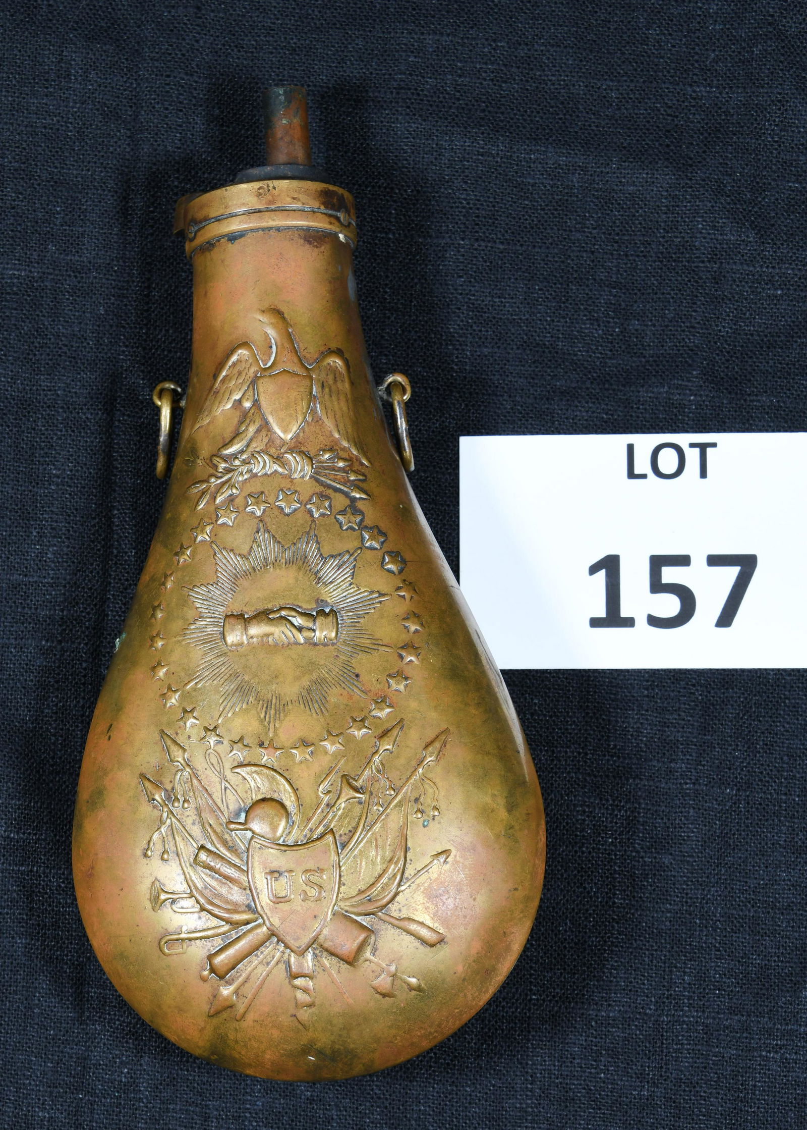 US Civil War Era Black Powder Flask: A US Civil War era "Peace" brass gun powder flask. This piece features a beautiful raised design on both sides with an eagle at the top, two hands clasped together inside a sunburst circle and framed