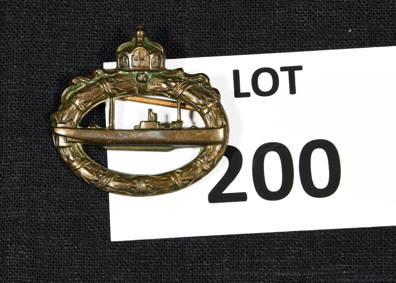 WWI Imperial German Navy U-Boat Submarine Badge: A WWI era Imperial German U-boat Submarine badge. This badge features a u-boat submarine inside of an oval oak leaf wreath with crown at the top. Reverse is marked "Walter Schot, feg." *notes- tarnish