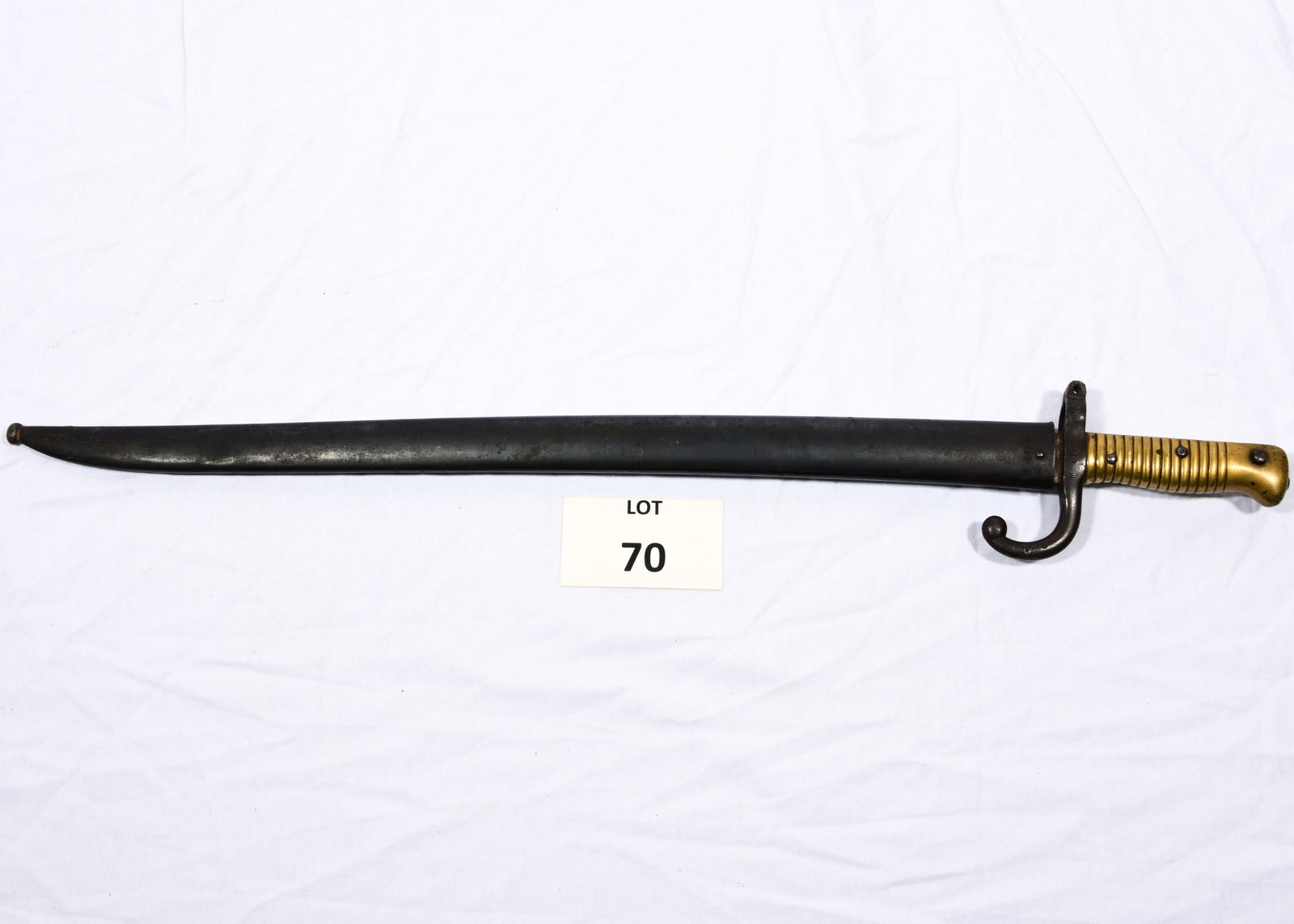 French Chassepot Bayonet and Scabbard: A French Chassepot bayonet and scabbard dated 1872. Edge of blade is engraved in French. Grip is stamped with "M 4148." 27 1/2" long. *notes- scratches and wear throughout.