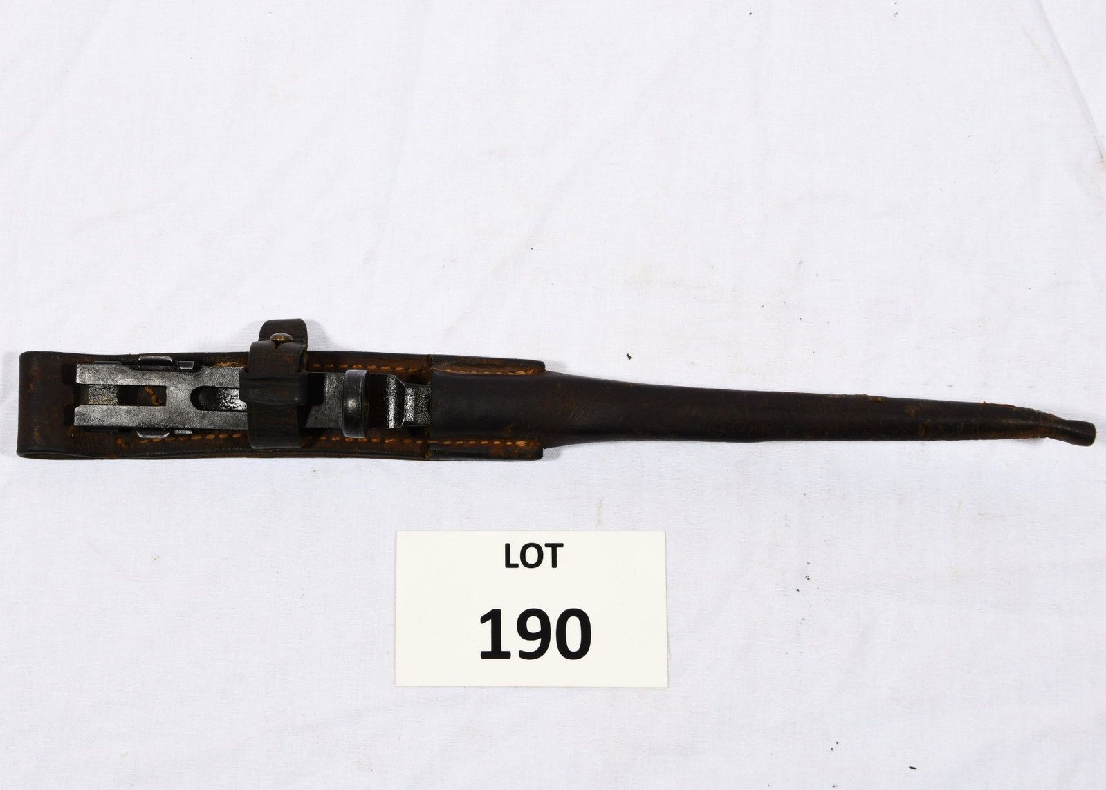 Antique Bayonet with Leather Scabbard: An antique bayonet with leather scabbard and frog. The bayonet measures 13" long and is triangular. *notes- wear from age and use.