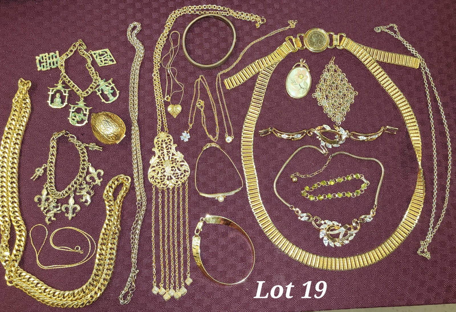 Lot of Gold Tone Jewelry: A lot of gold tone jewelry including several longer necklaces great for layering. Of note is a gold tone walnut that holds a thimble.