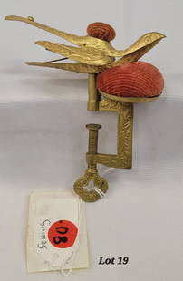 Antique Victorian Brass Sewing Bird: An antique Victorian brass sewing bird with pin cushion. This piece has a screw clamp bottom for attaching to table or sewing area. The bird's mouth doubles as a clip for holding fabric or other sewin