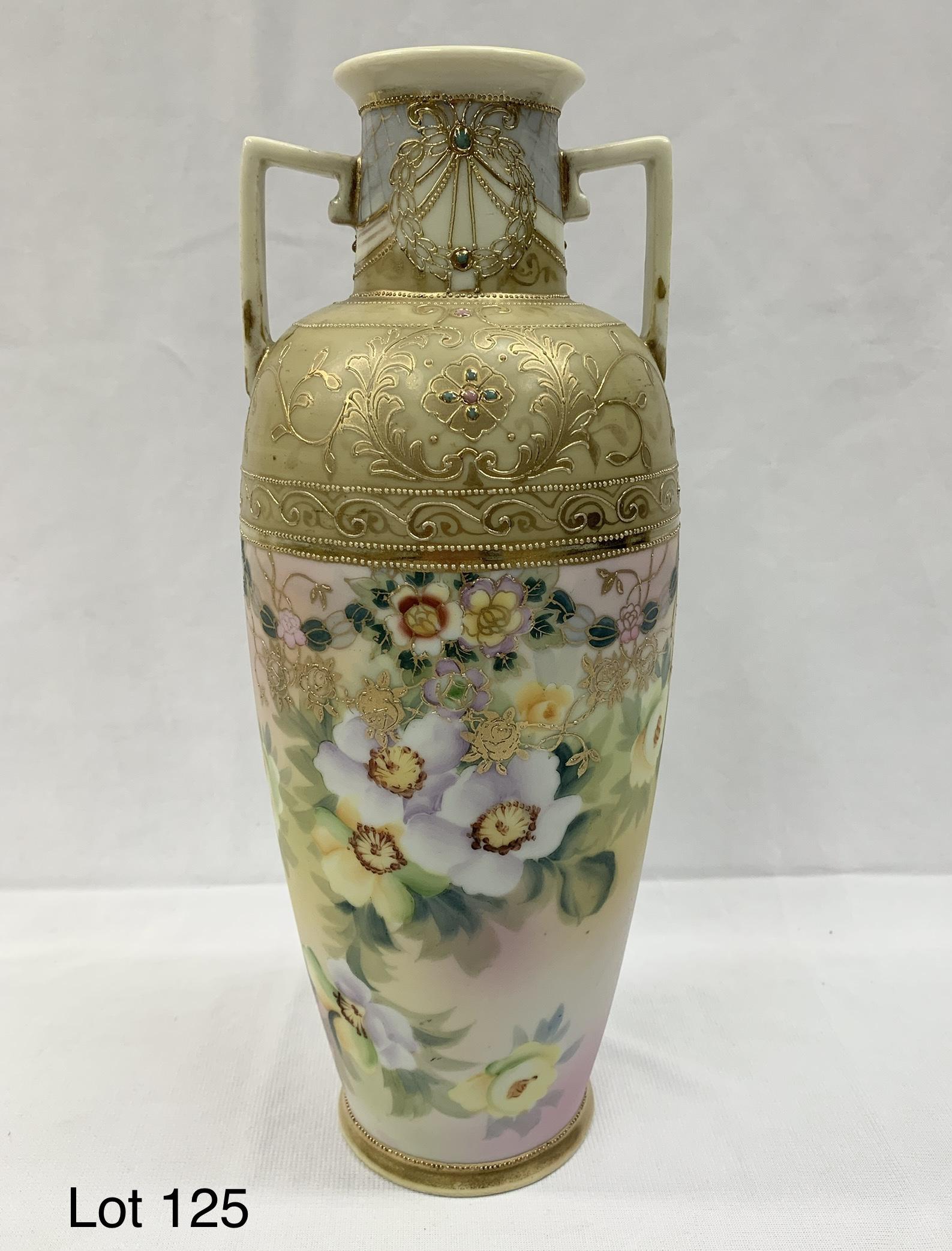 Hand Painted Nippon Vase: A hand painted Nippon vase with handles on each side. The exterior has clusters of colorful flowers wrapped around it. the top near the rim has beautiful golden accents. The underside bares the Nippon