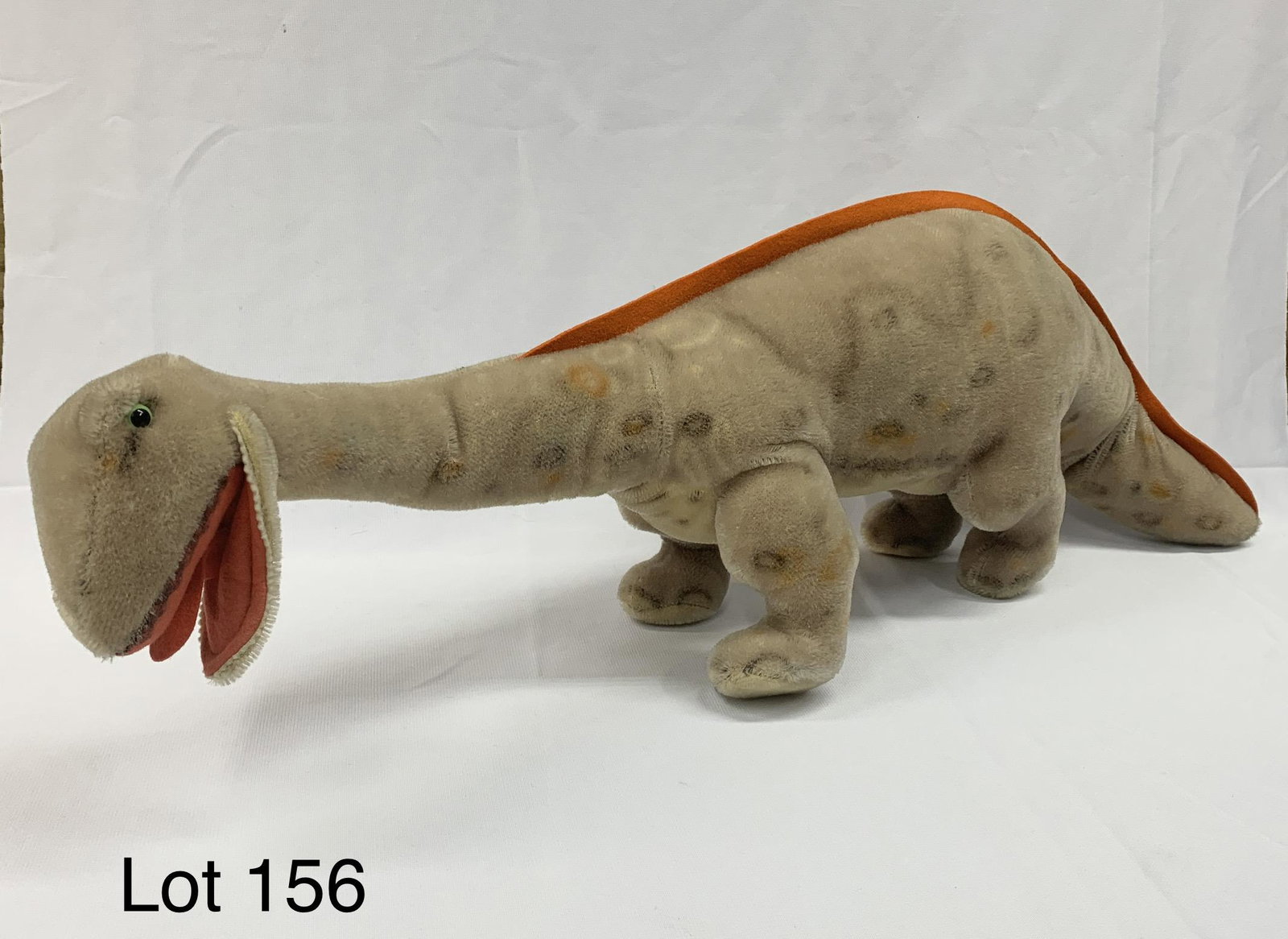 Vintage Steiff 28" "Brosus" Mohair Dinosaur: A rare vintage Steiff "Brosus" brontosaurus dinosaur plush doll. This toy has beige mohair fur with airbrushed details, orange felt down the back and tail and black and green glass eyes. Missing Steif