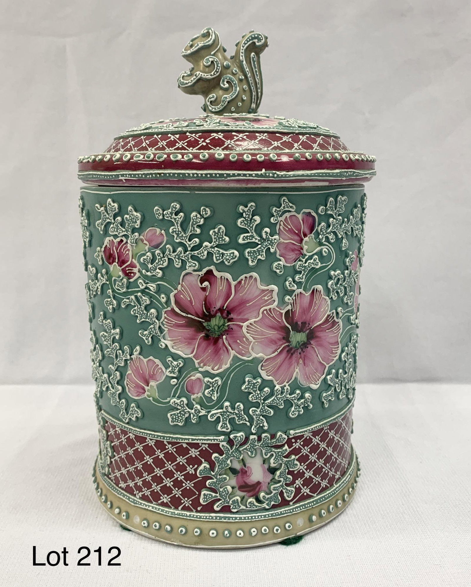 Antique Nippon Moriage Porcelain Humidor: An antique Japanese Nippon moriage porcelain cigar humidor with hand painted floral decoration and squirrel finial on lid. 7 3/4" x 4 3/4". Underside is unmarked.