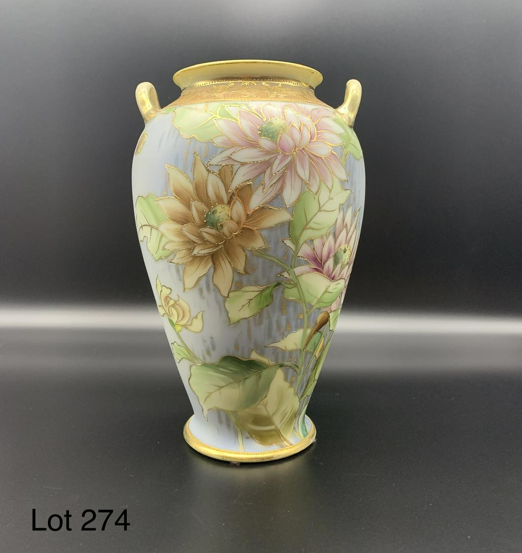 Nippon Two handled Vase: Hand painted Nippon vase with floral decoration and gold toned accents. Makers mark on underside of the vase. 8 1/4" tall.