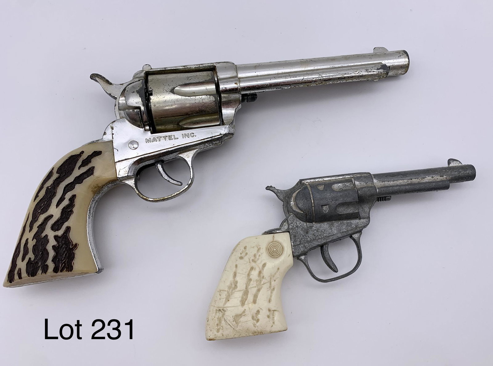 Pair Of Vintage Toy Guns: A Shootin' Shell 45 made by Mattel, Inc. and a smaller Top Gun Jr. *notes- both have wear and scratching. In working condition. Larger gun is 10 1/2" long.