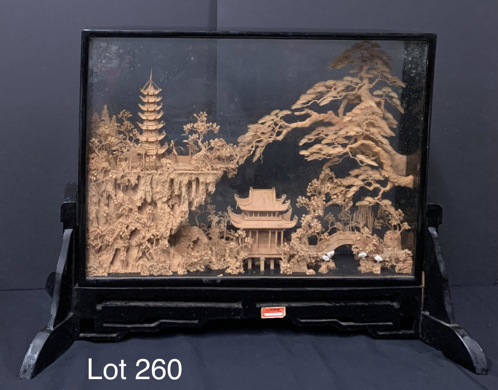 Vintage Chinese Handmade Cork Carving Diorama: A vintage Chinese handmade cork carving diorama of buildings and birds surrounded by trees. This unique piece is displayed in a black frame that measures 24" x 18" x 4". *notes- spotting on glass, scr