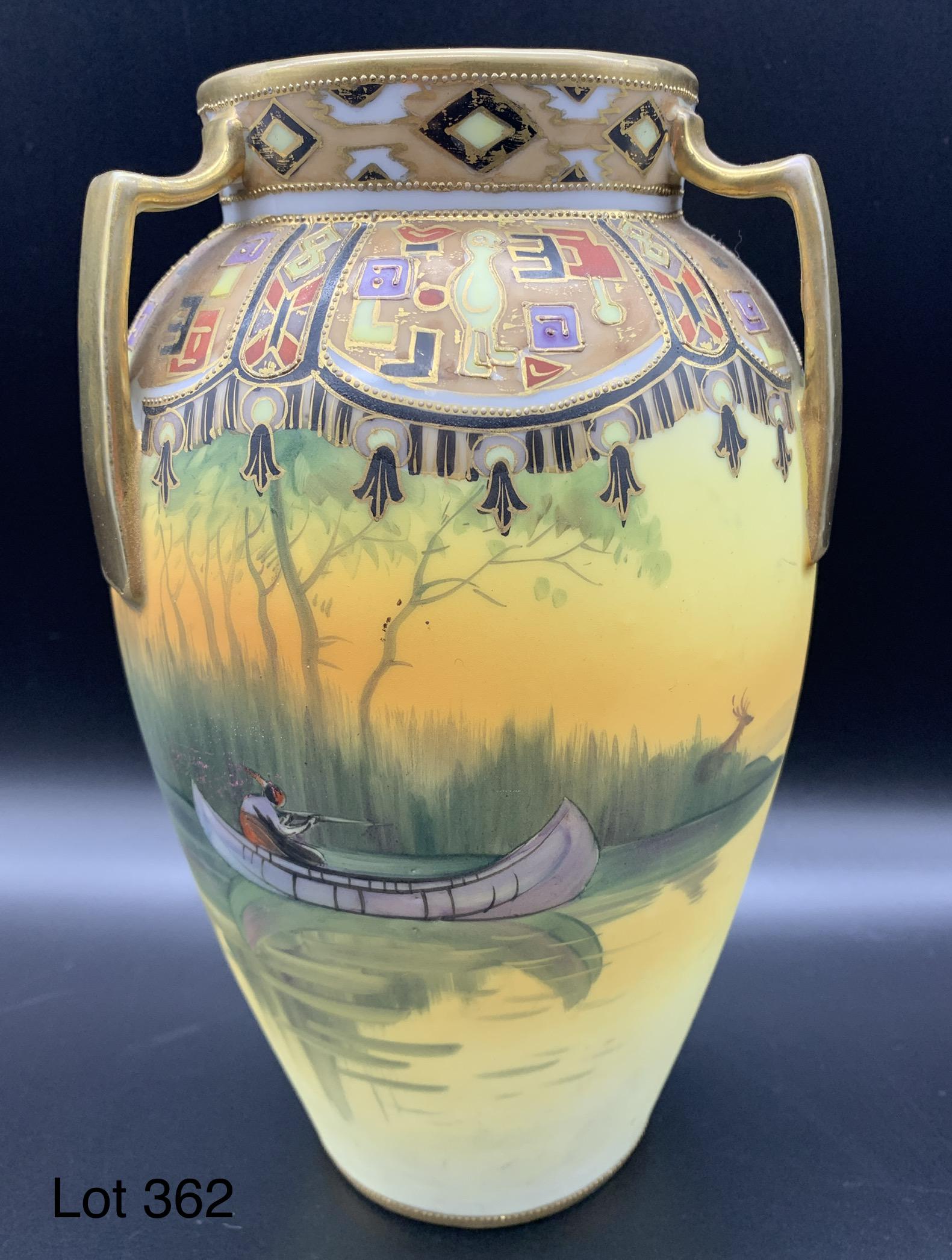 Nippon Urn Vase with painted scene of a Native American Hunter: A Nippon urn vase with three handles and a hand painted scene of an Native American in a canoe aiming to shoot a buck in the tall grass on a lake. Gold toned decoration along the top and on the handle