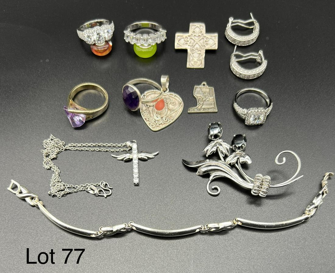 Sterling Silver Lot: Collection of sterling silver jewelry including rings, pendants, a bracelet and a brooch. Stones featured are amethyst, coral, several clear stones and more.