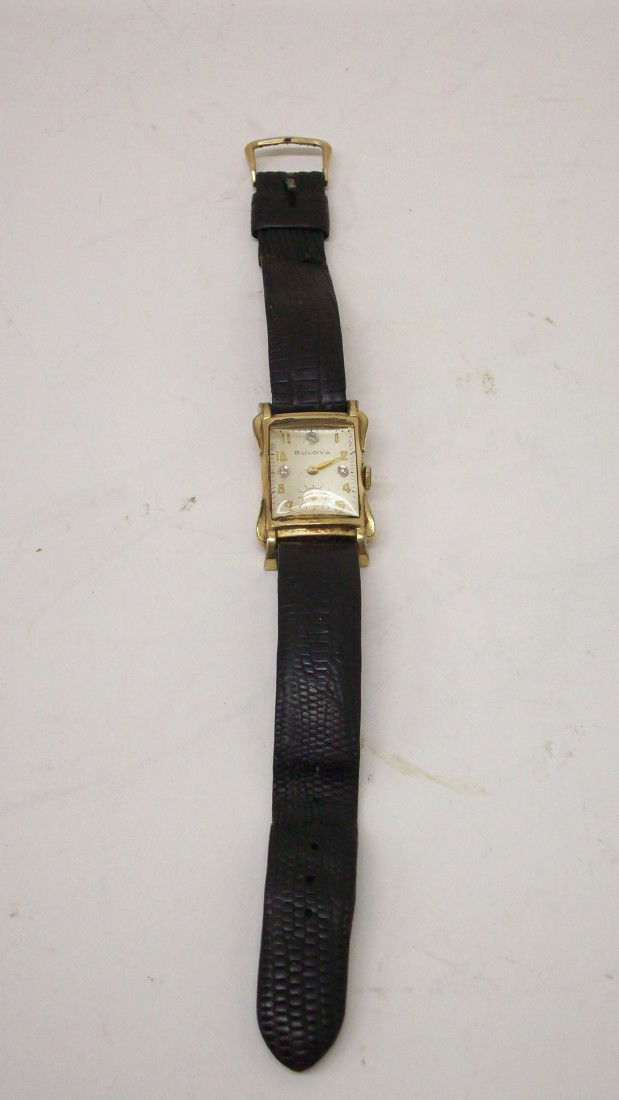 Bulova Men's Watch: 1952, 17 Jewels, 3 Diamonds in the face, 10KT rolled gold plate case, glass is clear, leather strap is rough.