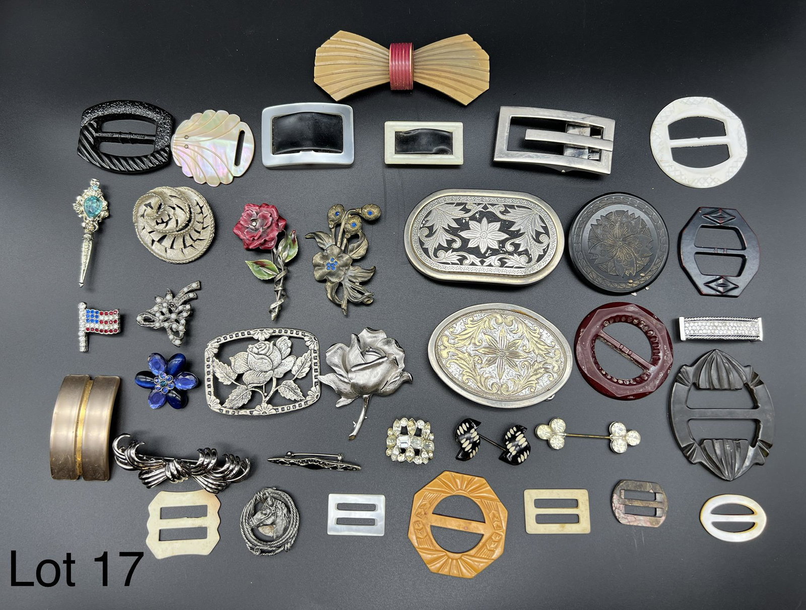 Lot of Belt Buckles and Brooches: A variety of belt buckles and brooches. Materials include bakelite, metal, plastic and more.