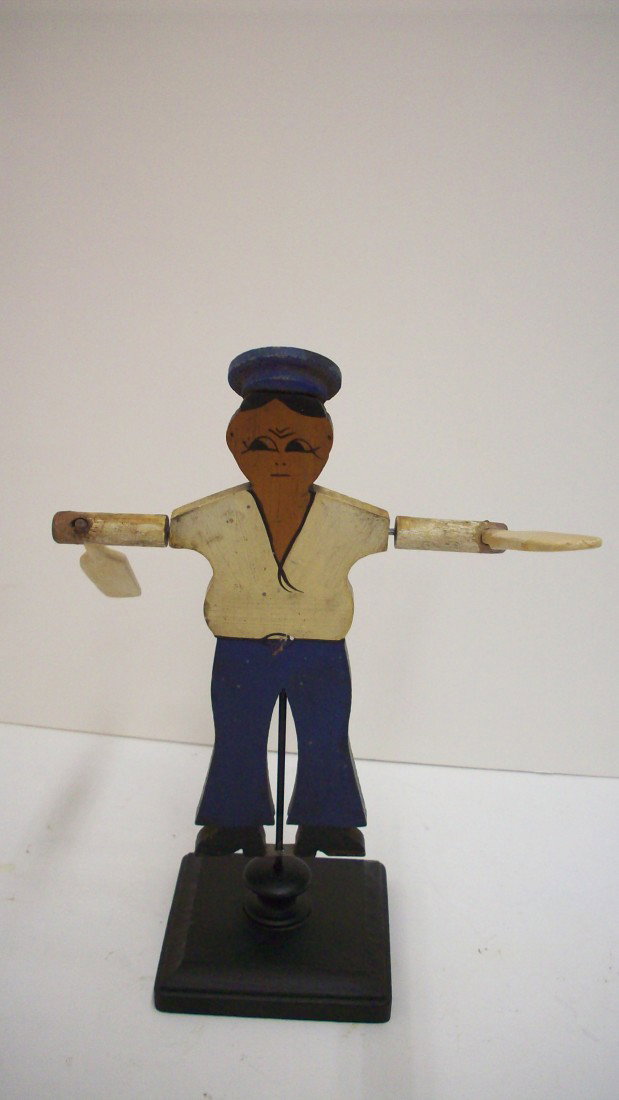 Whirligig of Sailor: Wooden early paddle-style whirligig of sailor. Old paint with minor loss. Turn of the century. On a newer base. Great condition.
