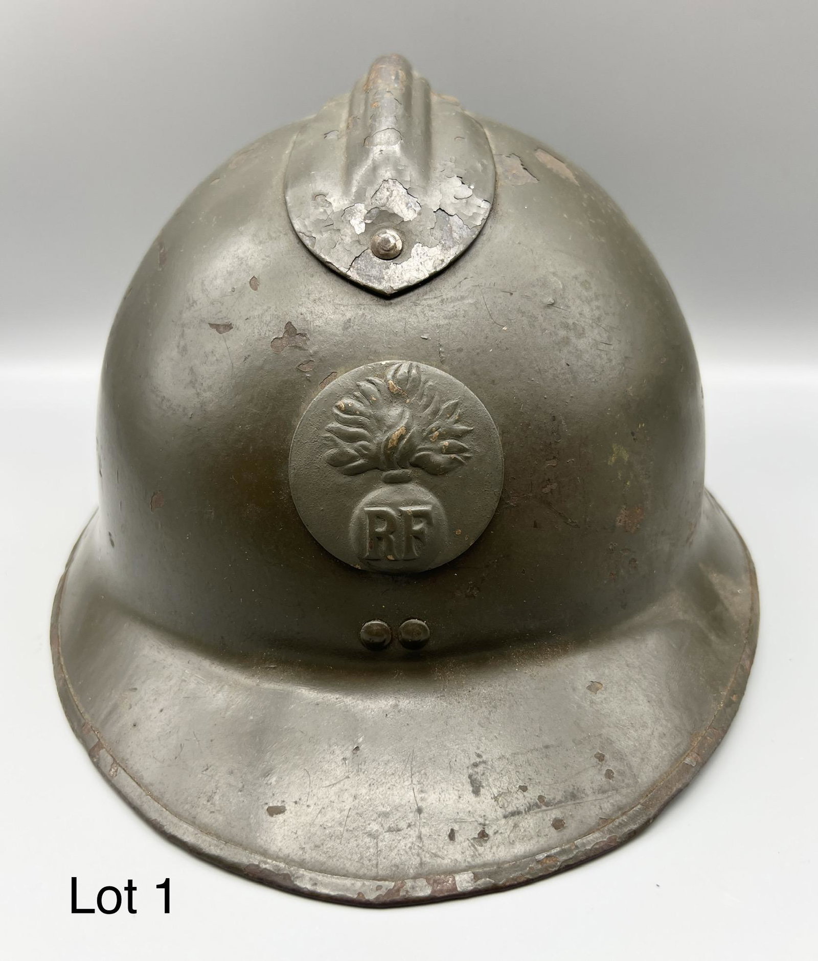 WWII French Adrian Helmet: 1926 model WWII French Army Adrian helmet. Helmet made of steel, with original RF army emblem, leather interior and strap. Measures 12 1/2" long, 6 1/4" tall. *notes - paint chipped in some places, in