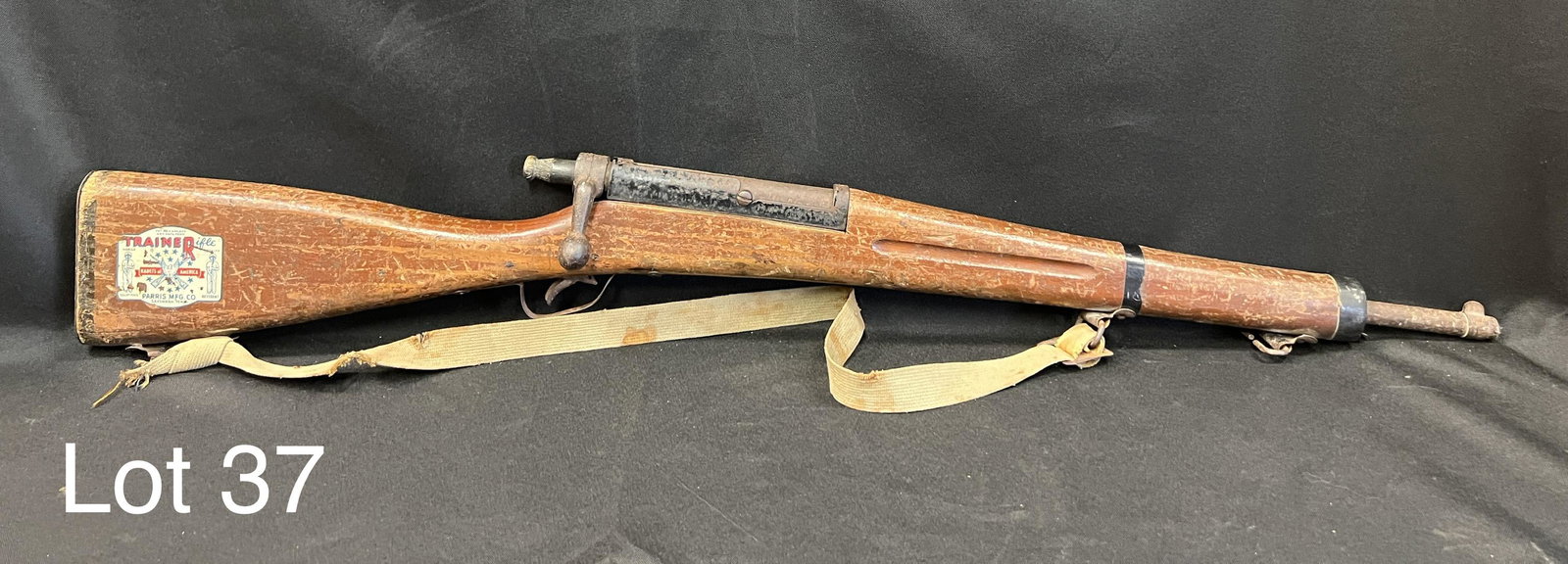 WWII-Era Parris Mfg. Co. Trainerifle: WWII-Era Parris Mfg. Co. Kadets of America Trainerifle, modeled after 1903 Springfield. Bolt action still works, makers marks and serial number on stock. Measures 34 3/4" long. *note - patina on barre