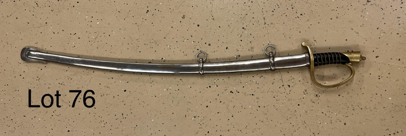 Vintage Indian Replica Cavalry Sword: Vintage replica of a 19th century cavalry sword, marked from India at the base of the blade. Metal sheath, bronze and leather handle. Measures 41 1/2" long.
