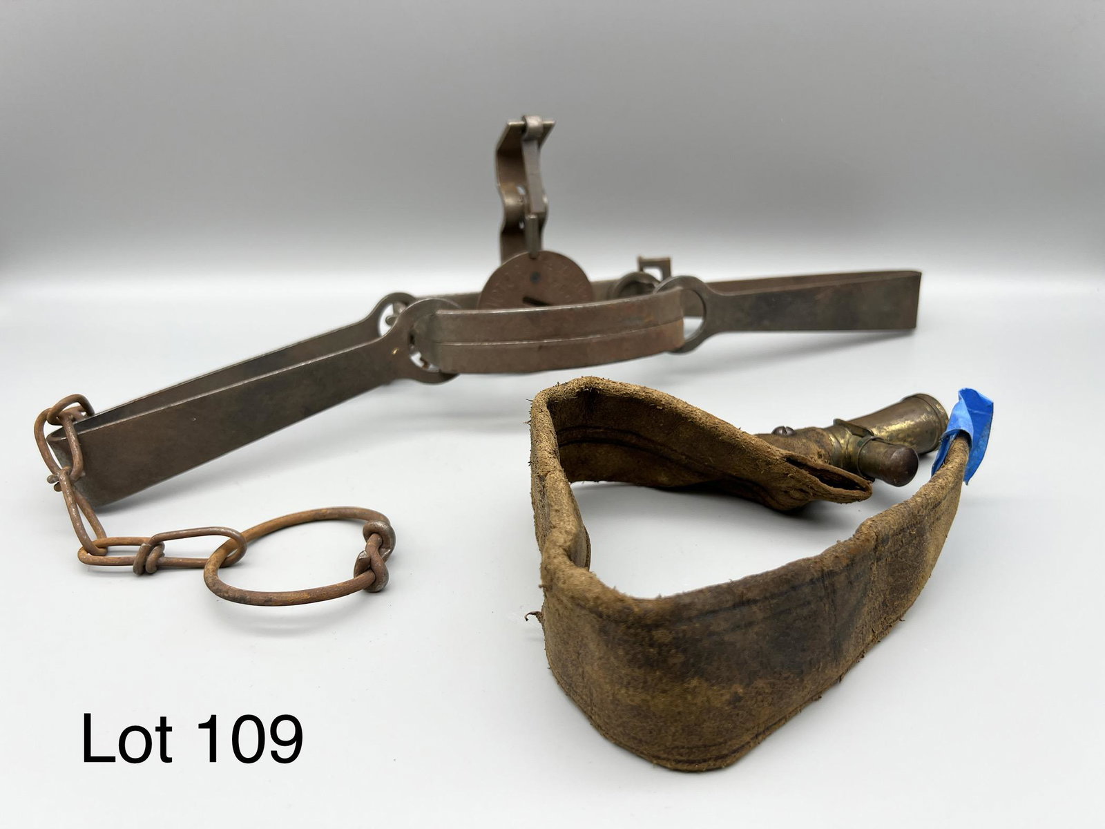 Lot of Hunting Equipment: Lot of hunting equipment including an Oneida Victor No. 2 spring trap from the Animal Trap Co. of Lititz, PA, and an antique leather powder flask. Trap missing spring, original chain still attached. T