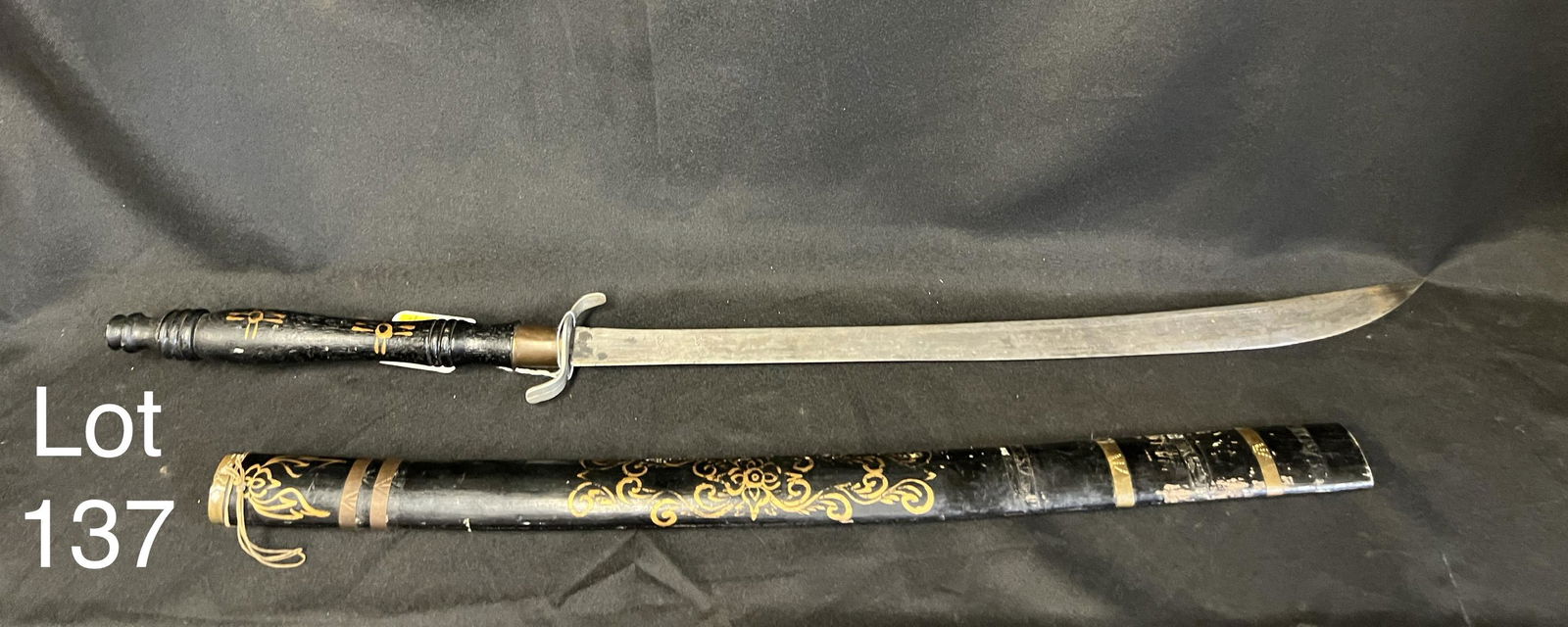 Antique Middle Eastern Sword: Antique Middle Eastern wood painted sword in all black with gold design work. Handle is also wood with metal guard, no makers mark noted. Sword measures 33 7/8", 37" with scabbard. *notes - some chipp