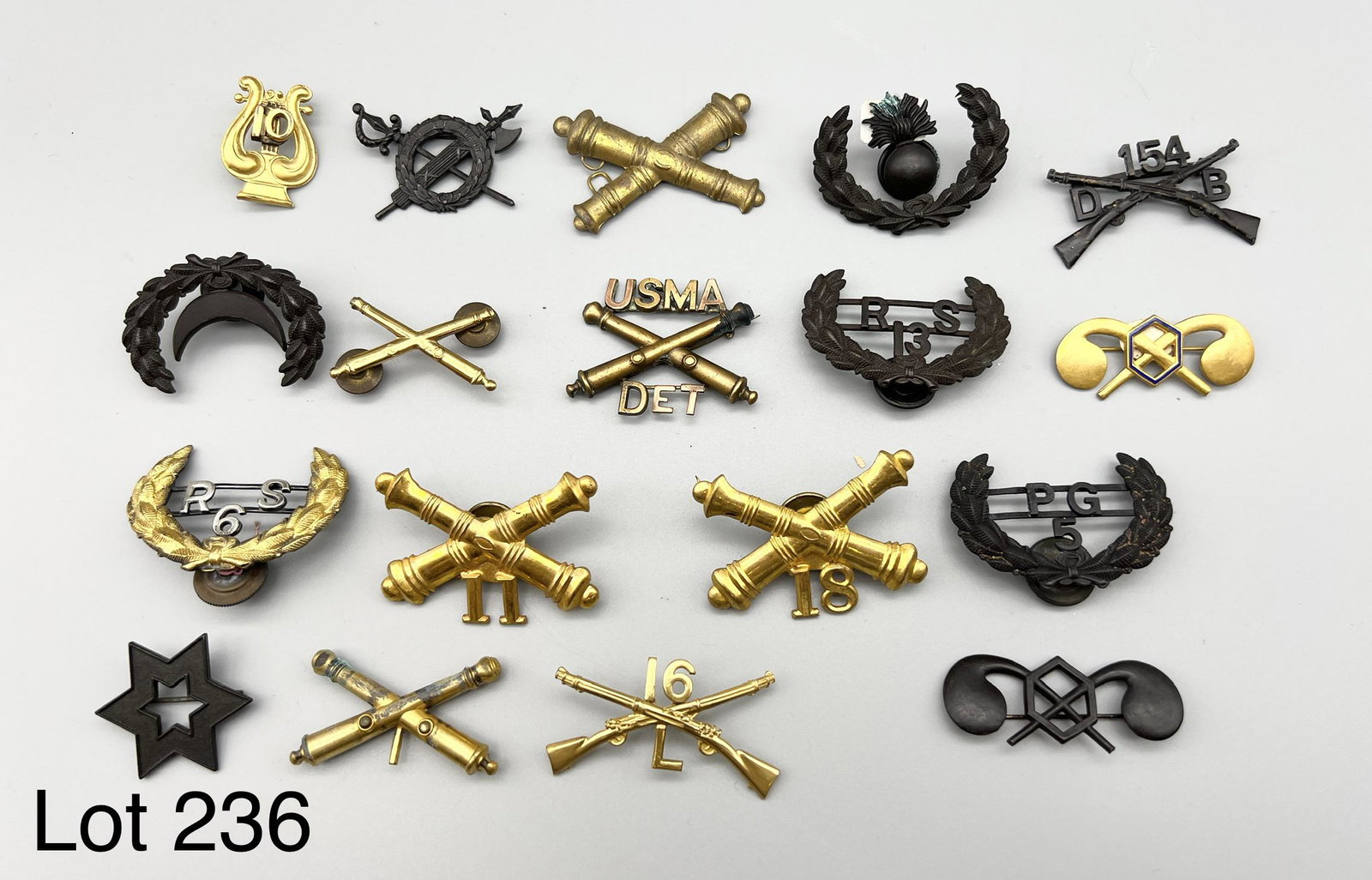 Collection of Military Insignias From Spanish American War: A collection of antique military badges including artillery, chemical corps and more dating back to the Spanish American War (1898-1902).