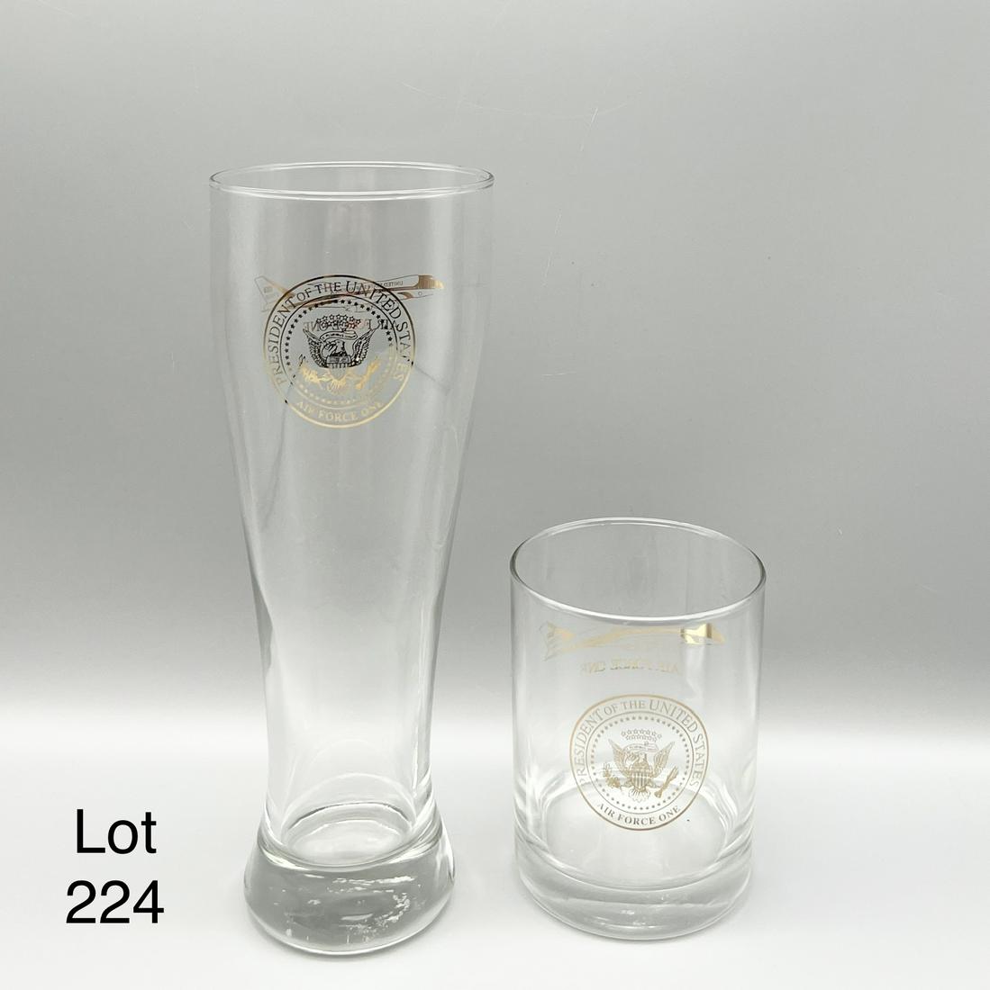 Air Force One Glassware: Pair of President of the United States Air Force One glasses. Includes a pilsner beer glass and a whiskey glass. Both have emblems for POTUS and Air Force One on each side. Pilsner glass is 9 1/4" tal