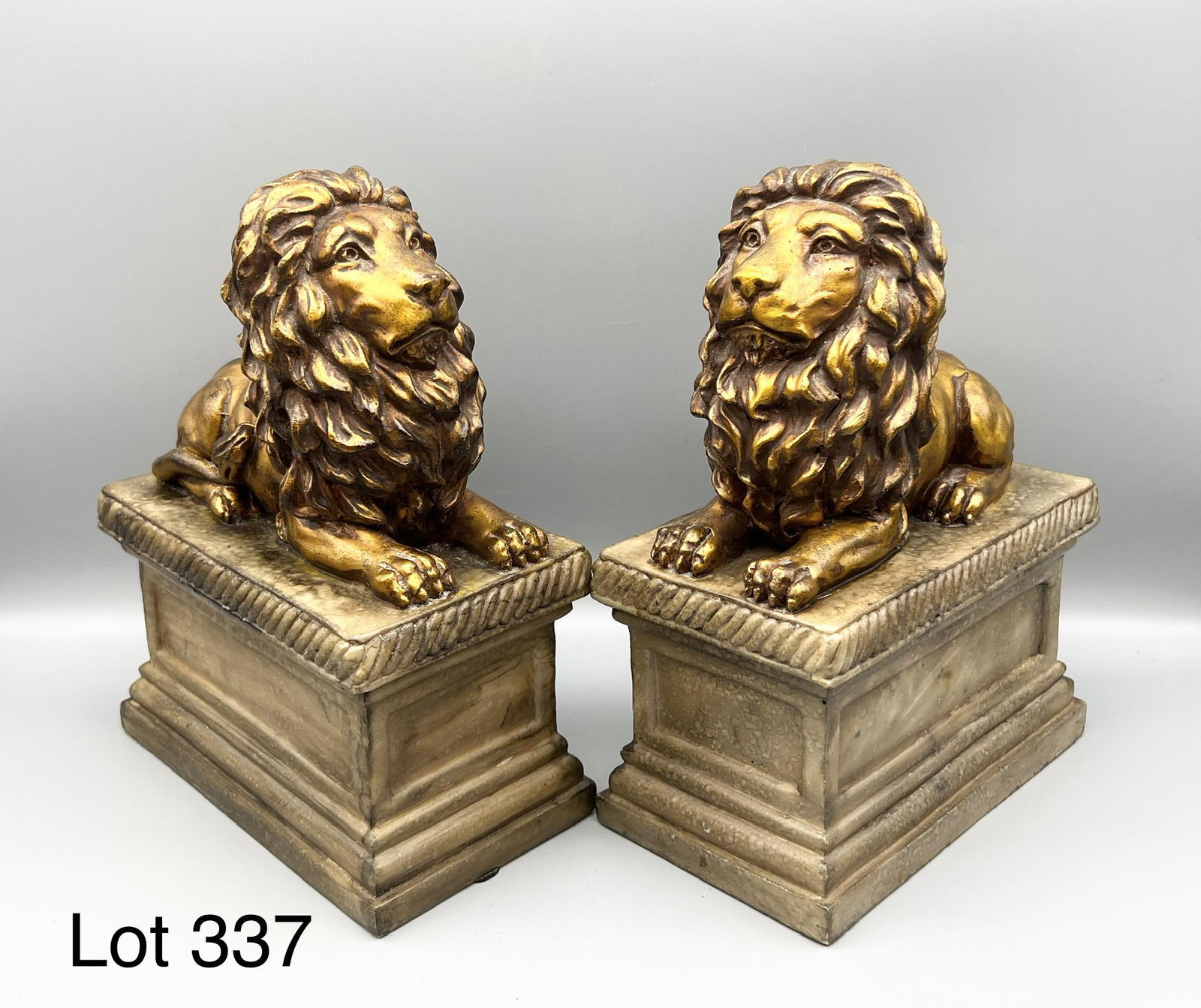 Vintage Lion Bookends: A pair of vintage lion bookends. The both lay on a rectangular base and are painted gold. Each measures 9 1/2" x 6 3/4" x 3 1/4".