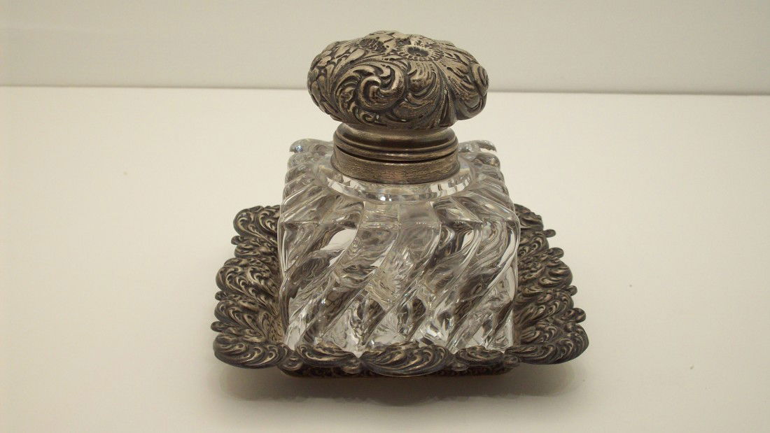 Sterling Topped Inkwell with Sterling Tray: Inkwell: 5" X 3 1/2", Tray: 5 7/8" X 1". Glass inkwell with a hand chaised floral motif cap. Sterling hand chaised tray. Both hallmarked sterling, from England, and in great condition with no chips or