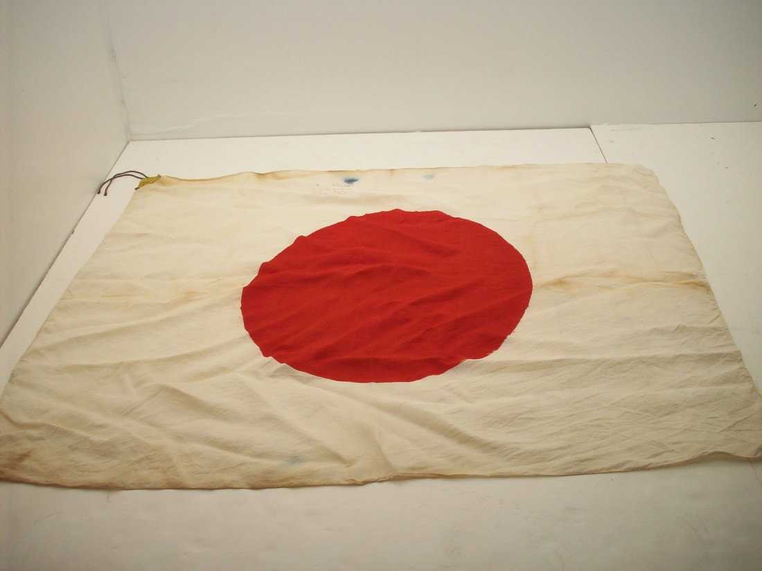 Japanese National Circle Of The Sun Flag: 33" X 27", Silk flag with heavy gold colored paper corners with tying strings. Shows age with staining and a few small holes. Has two Signatures with city and state.