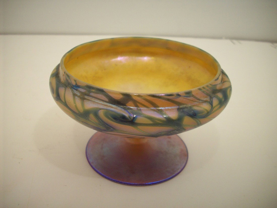 Durand King Tut Compote: 2 3/4" tall x 4 1/2" at widest point. This Durand shape # is 2014 as shown on page 174 of DURAND The Man And His Glass by E. Meschi. Iridescent yellow background with green swirls and a clearish bas