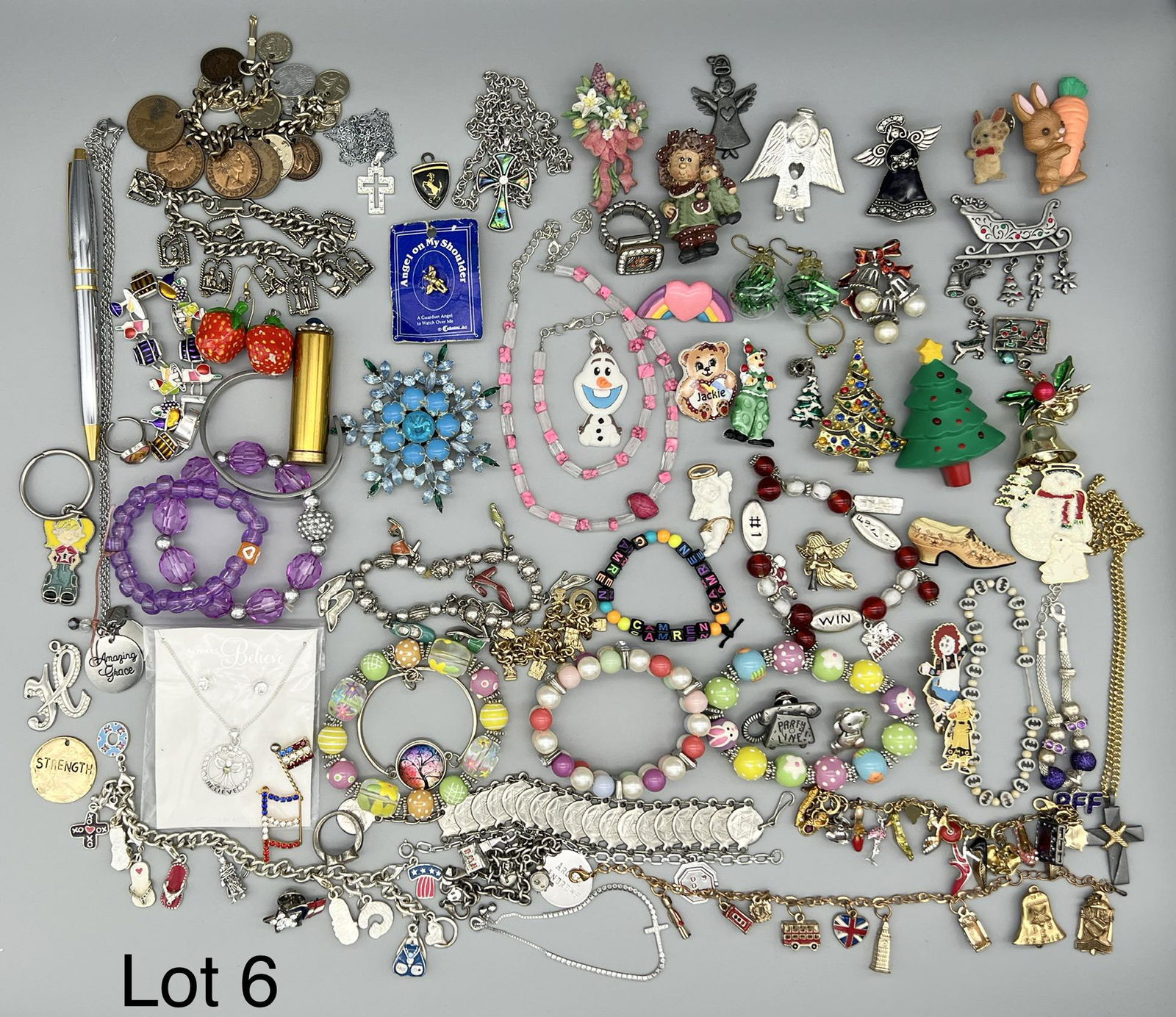 Lot of Novelty Costume Jewelry: A mixed collection of costume jewelry including holiday, religious, children's, travel and more. There are several themed charm bracelets, Christmas brooches, crucifixes necklaces and more.