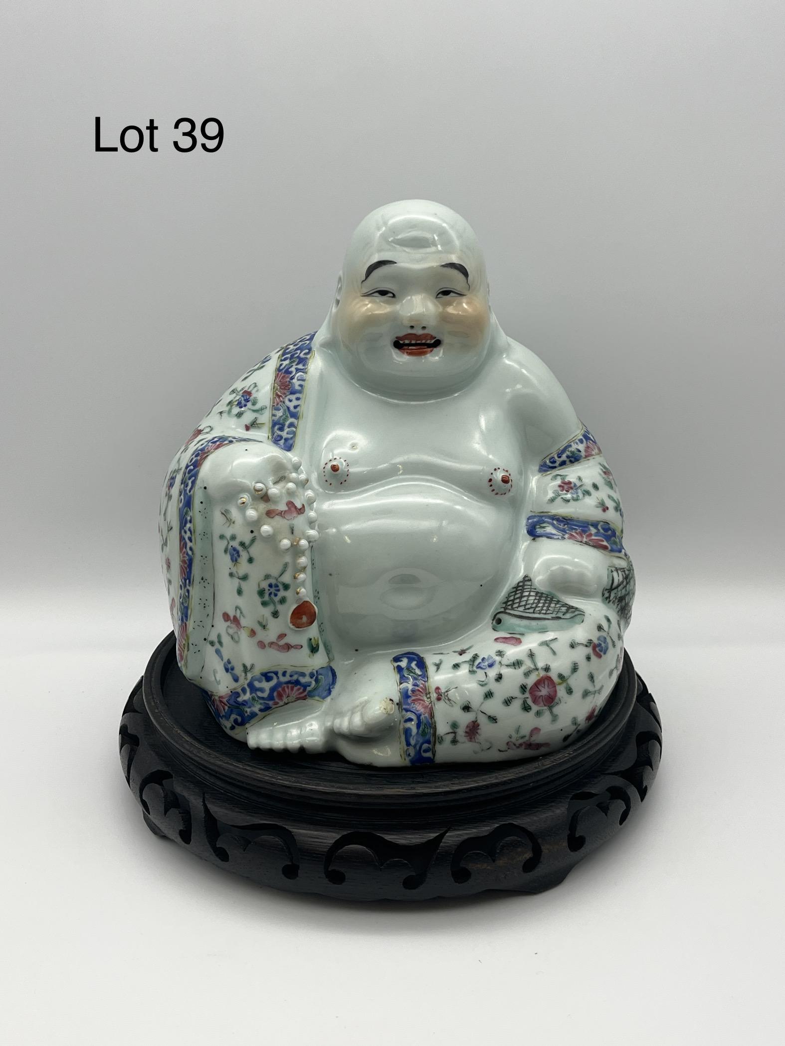Chinese Porcelain Buddha Statue: Chinese porcelain statue of a happy Buddha on a wood base, depicted in pink and blue floral robes. Measures 9" tall on base, 7 1/4" across.