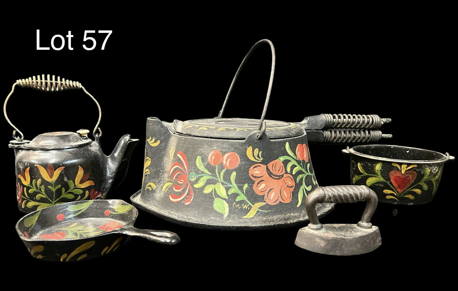 Collection Antique of Hand Painted Cast Iron Wagner Ware: A cast iron group of early 20th century Wagner Ware with handpainted floral and fruit design. Includes a waffle iron, mini tea kettle, mini frying pan and a mini cauldron. Also includes a small unbran